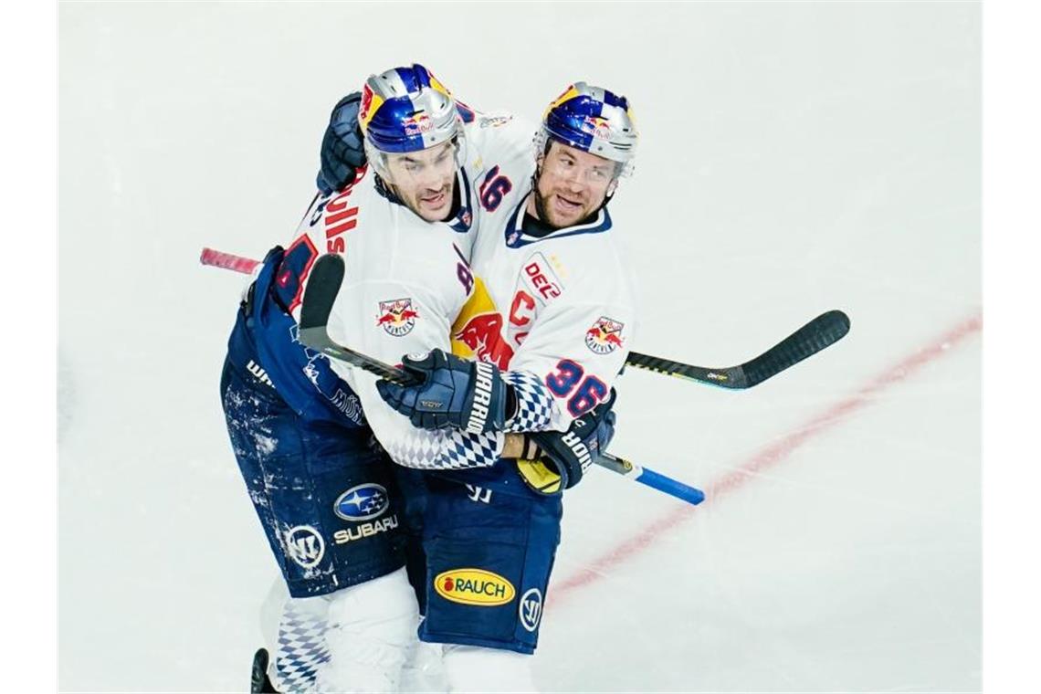 EHC-Torschütze Trevor Parkes (l) feiert mit Jubilar Yannic Seidenberg den Auswärtssieg in Mannheim. Foto: Uwe Anspach/dpa