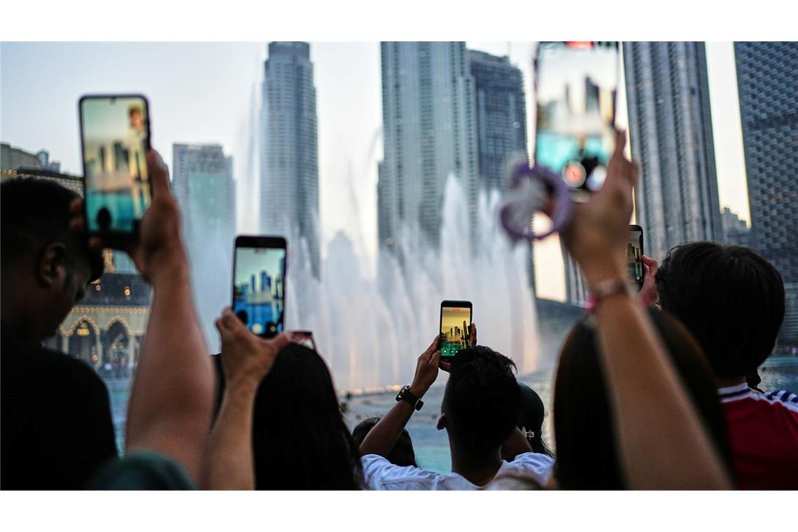Eid al-Adha in Dubai: Besucher fotografieren den Brunnen vor der Skyline