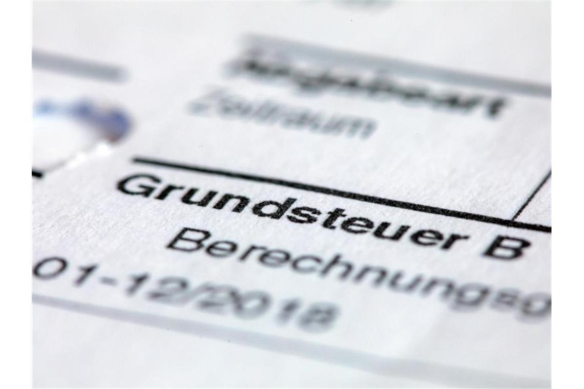 Ein Abgabenbescheid für die Entrichtung der Grundsteuer liegt auf einem Schreibtisch. Foto: Jens Büttner/zb/dpa