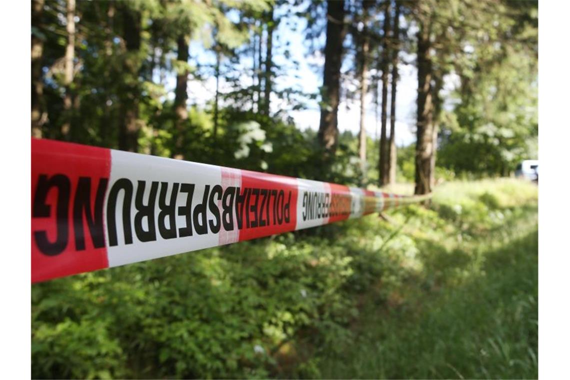Leichenfund: Todesursache von junger Frau weiter unklar Ein Absperrband der Polizei ist in einem Waldstück angebracht. Foto: Bodo Schackow/ZB/dpa/Symbolbild