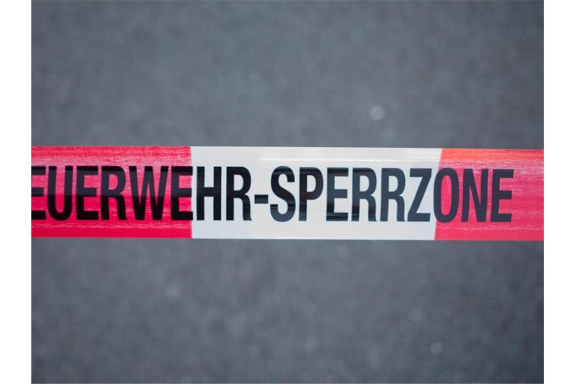 Frau stirbt bei Wohnungsbrand Ein Absperrband mit der Aufschrift "Feuerwehr-Sperrzone" ist an einem Unfallort gespannt. Foto: Daniel Bockwoldt/Archivbild