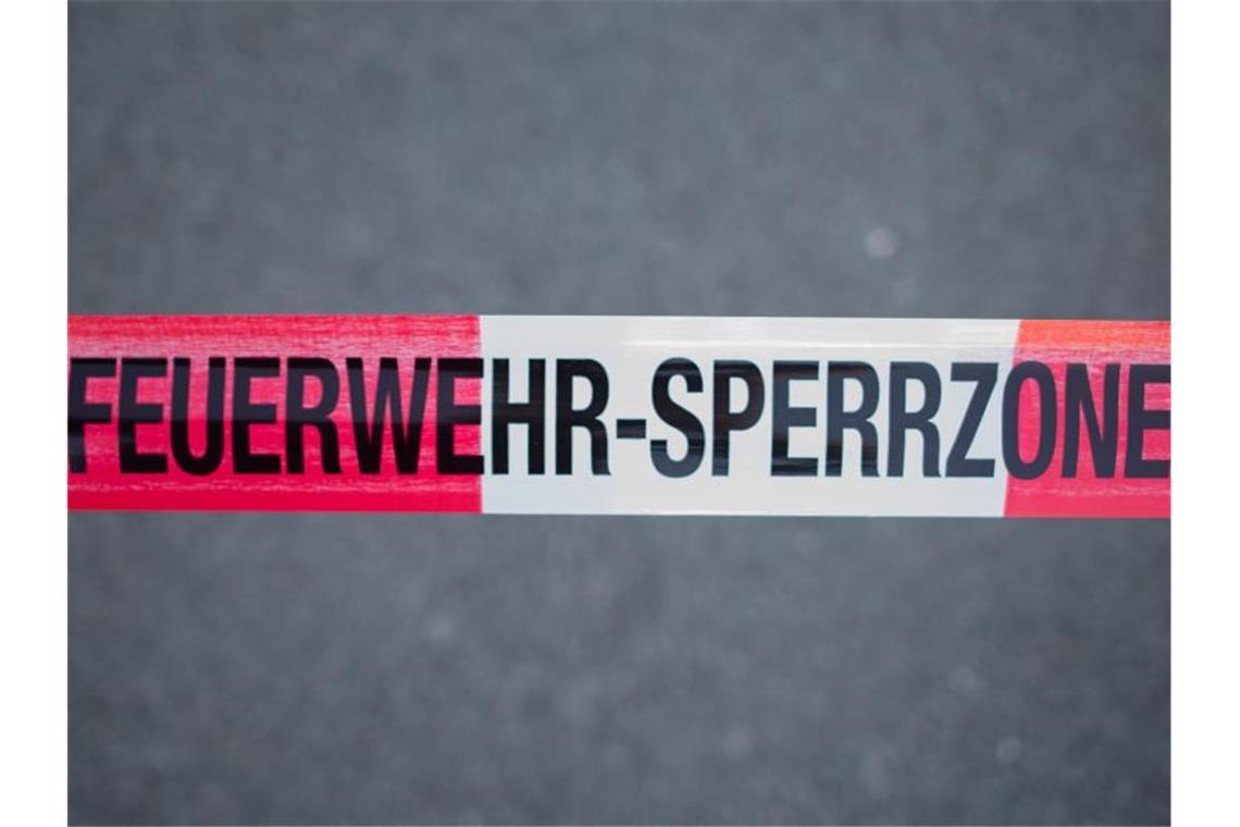 Waldbrände entlang der Enztalbahn: Brandstiftung vermutet Ein Absperrband mit der Aufschrift "Feuerwehr-Sperrzone" ist über eine Straße gespannt. Foto: Daniel Bockwoldt/Archivbild