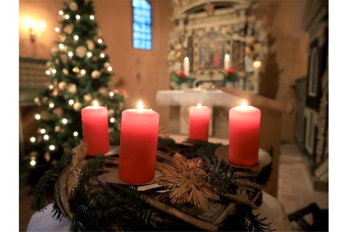 Kirchen pochen auf Weihnachtsgottesdienste Ein Adventskranz steht vor dem Altar beim Gottesdienst. Foto: Peter Gercke/dpa-Zentralbild/ZB/Symbolbild