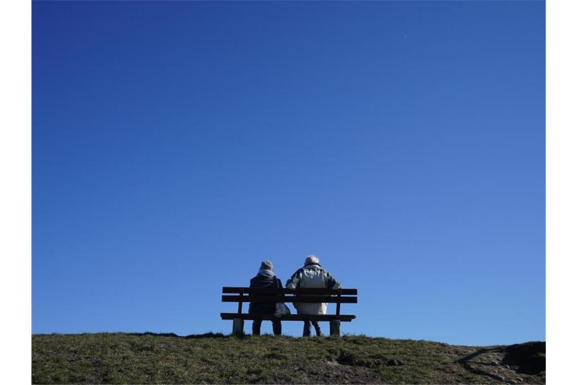 Eine Woche mit viel Sonne in Deutschland Ein älteres Paar bei strahlend blauem Himmel und Sonnenschein auf einer Bank an der Kieler Förde. Foto: Marcus Brandt/dpa