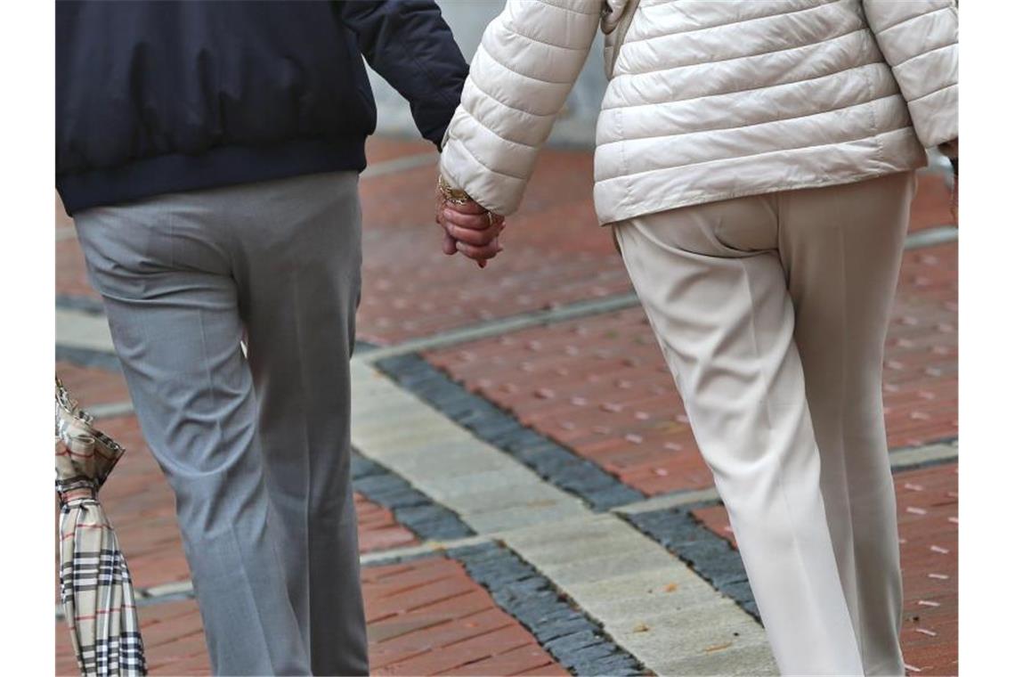 Ein älteres Paar Hand in Hand in einer Fußgängerzone. Foto: Karl-Josef Hildenbrand