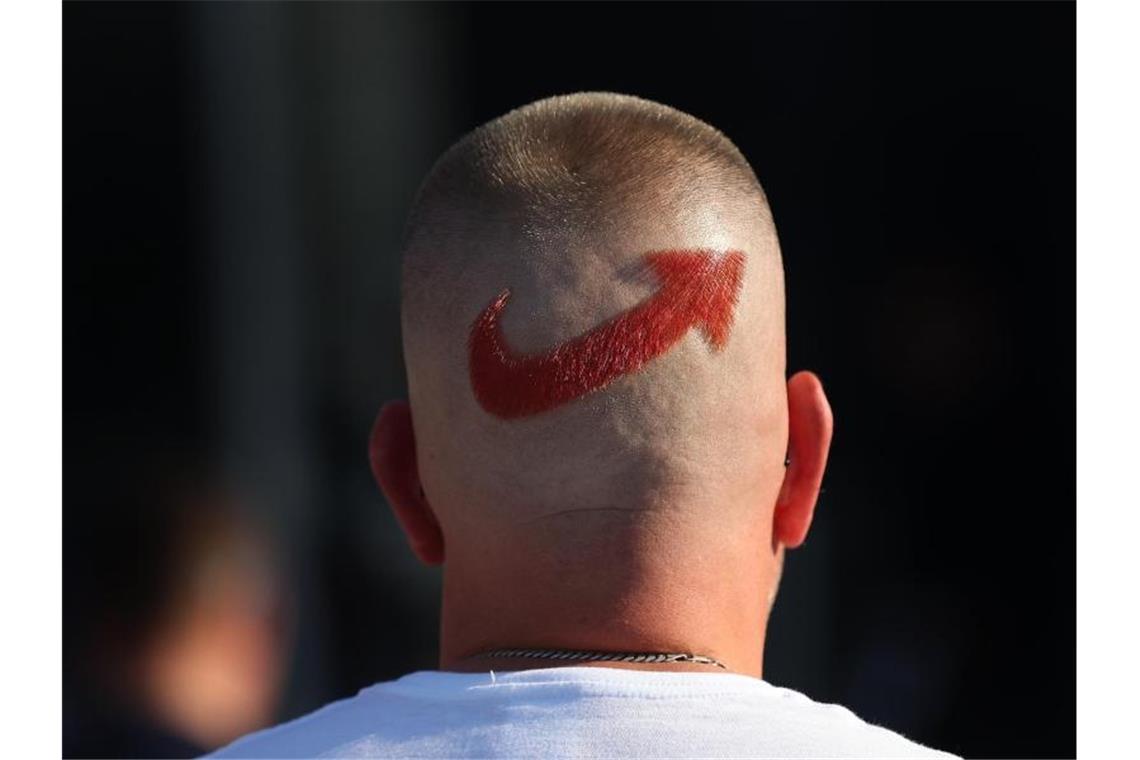 Ein AfD-Anhänger mit einem frisierten Logo der Partei auf dem Hinterkopf. Foto: Ronny Hartmann/dpa