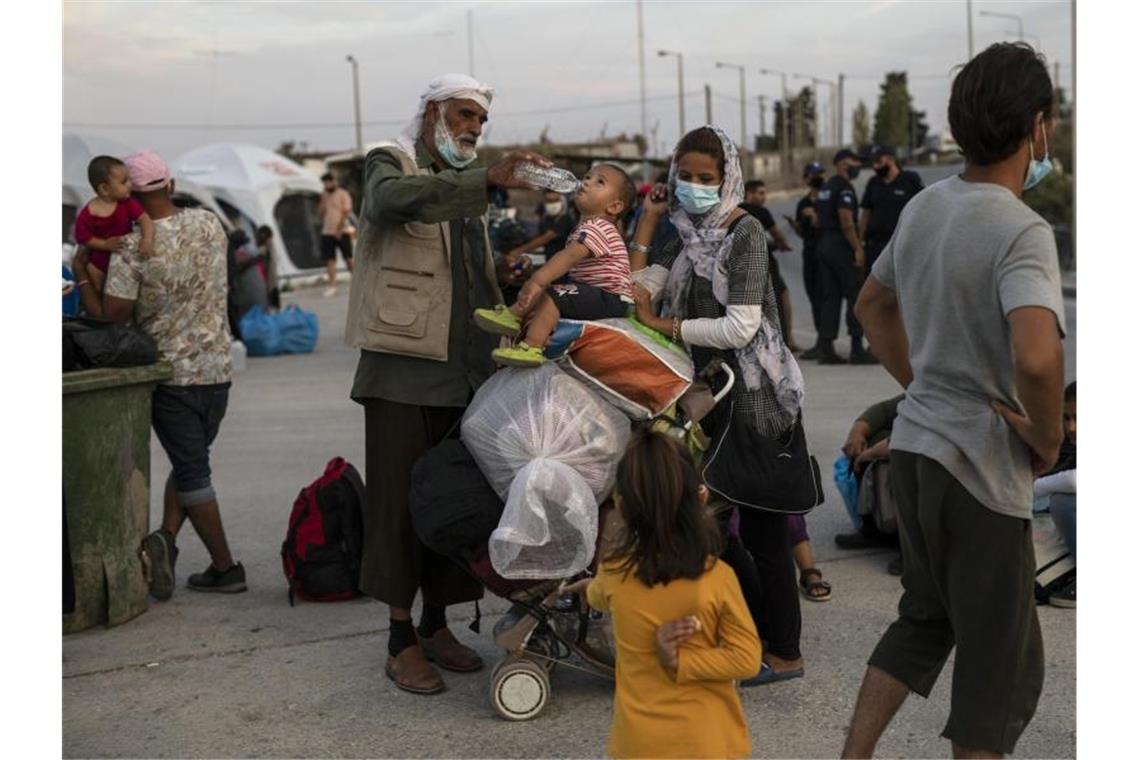 EU-Parlament macht Druck bei Asylreform Ein Afghane gibt einem Kind Wasser. Die europäische Migrationspolitik steht heute mal wieder im Fokus. Foto: Petros Giannakouris/AP/dpa