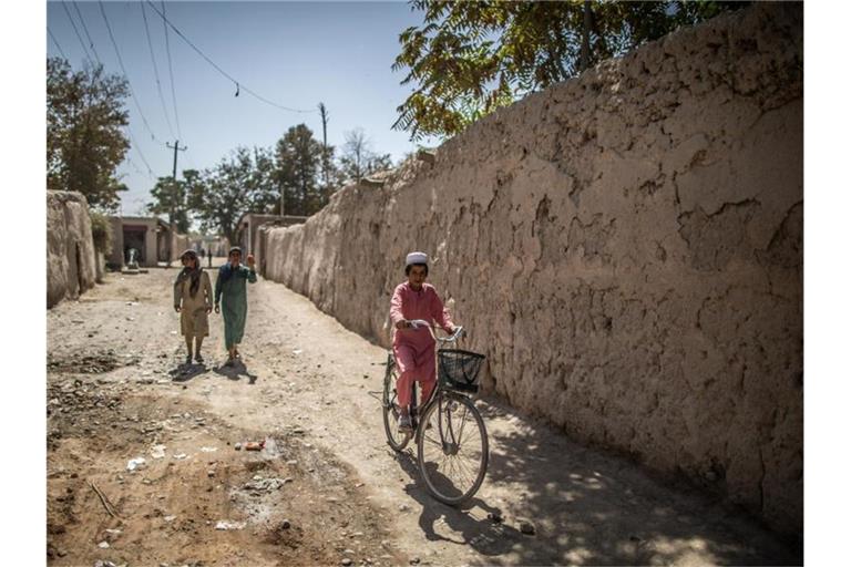 Ein afghanischer Junge fährt in Isa Khel außerhalb von Kundus Fahrrad. Foto: Oliver Weiken/dpa