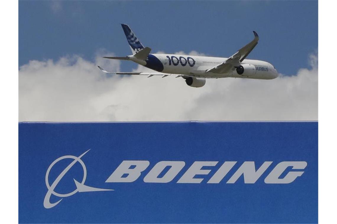 Ein Airbus vom Typ A350 - 1000 hebt bei einer Messe in Paris über einem Boeing-Schriftzug ab. Foto: Michel Euler/AP/dpa