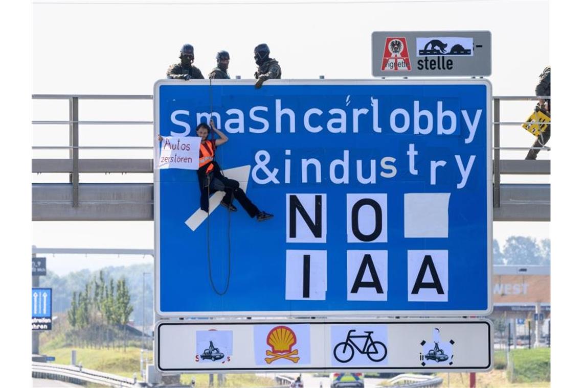 IAA-Gegner seilen sich von Münchner Autobahnbrücken ab Ein Aktivist bei einer Banneraktion an einer Schilderbrücke über der Autobahn A9 bei Fürholzen in Fahrtrichtung München. Foto: Matthias Balk/dpa