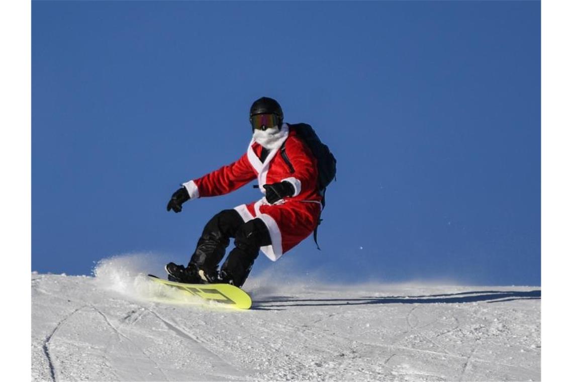Freie Fahrt für den Nikolaus: Lift am Feldberg läuft Ein als Nikolaus verkleideter Snowboardfahrer. Foto: Patrick Seeger/dpa/Archivbild