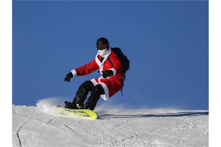 Ein als Nikolaus verkleideter Snowboardfahrer. Foto: Patrick Seeger/dpa/Archivbild