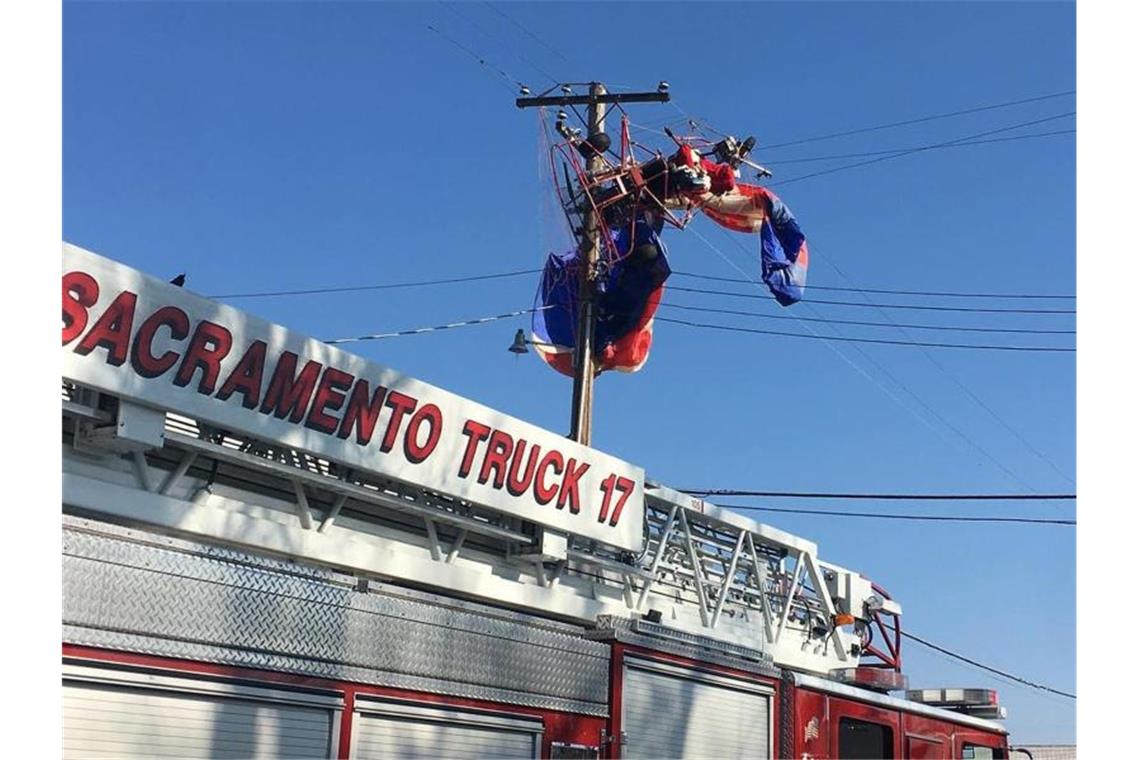 Ein als Weihnachtsmann verkleideten Mann ist mit seinem motorisierten Gleitsegler in einer Stromleitung hängengeblieben. Foto: Uncredited/California Highway Patrol/AP/dpa