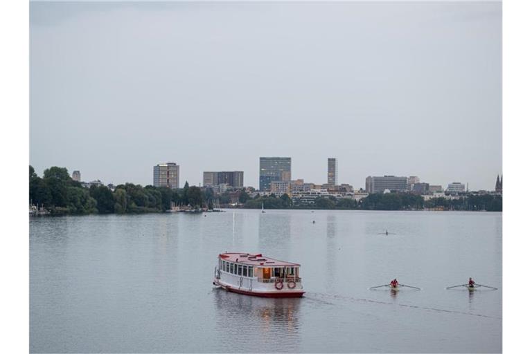 Ein Alsterdampfer fährt im trüben Augustwetter auf der Außenalster in Hamburg. Foto: Daniel Reinhardt/dpa