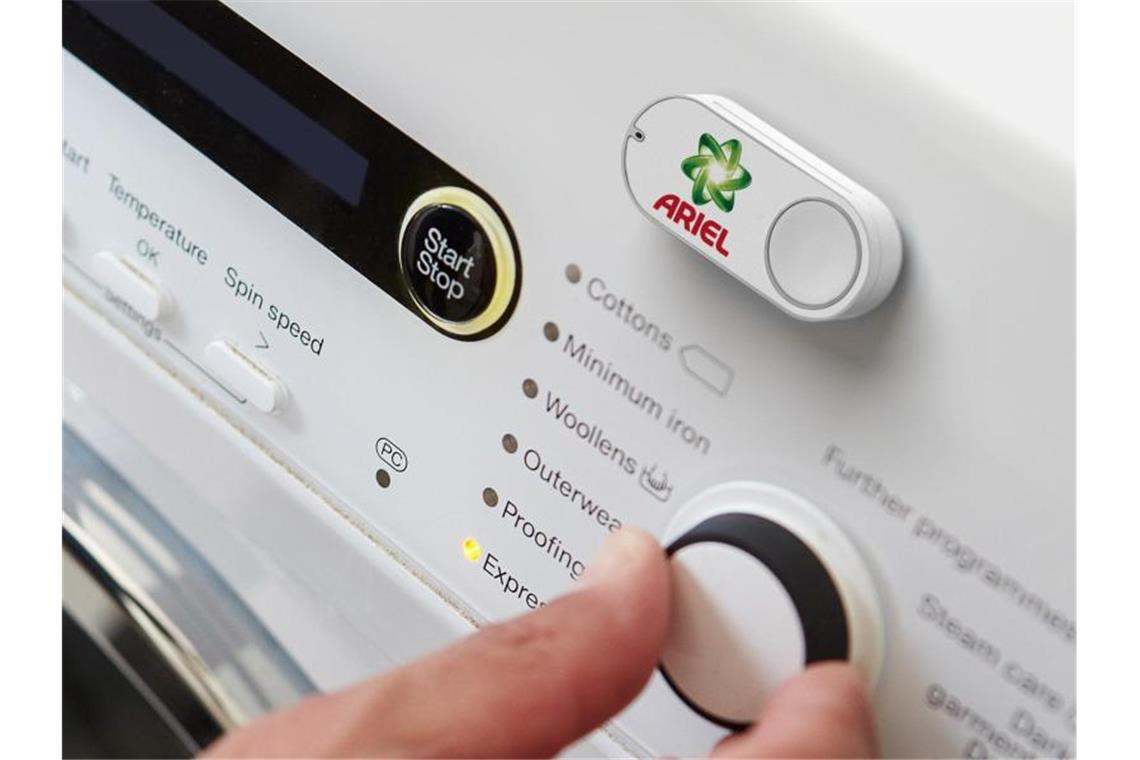 Ein Amazon-Dash-Button für die Marke Ariel klebt an einer Waschmaschine. Foto: Amazon