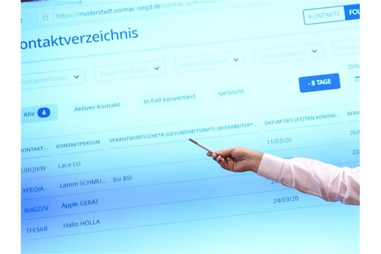 Ein Amtsarzt erklärt eine neue Software. Foto: Britta Pedersen/dpa-Zentralbild/dpa