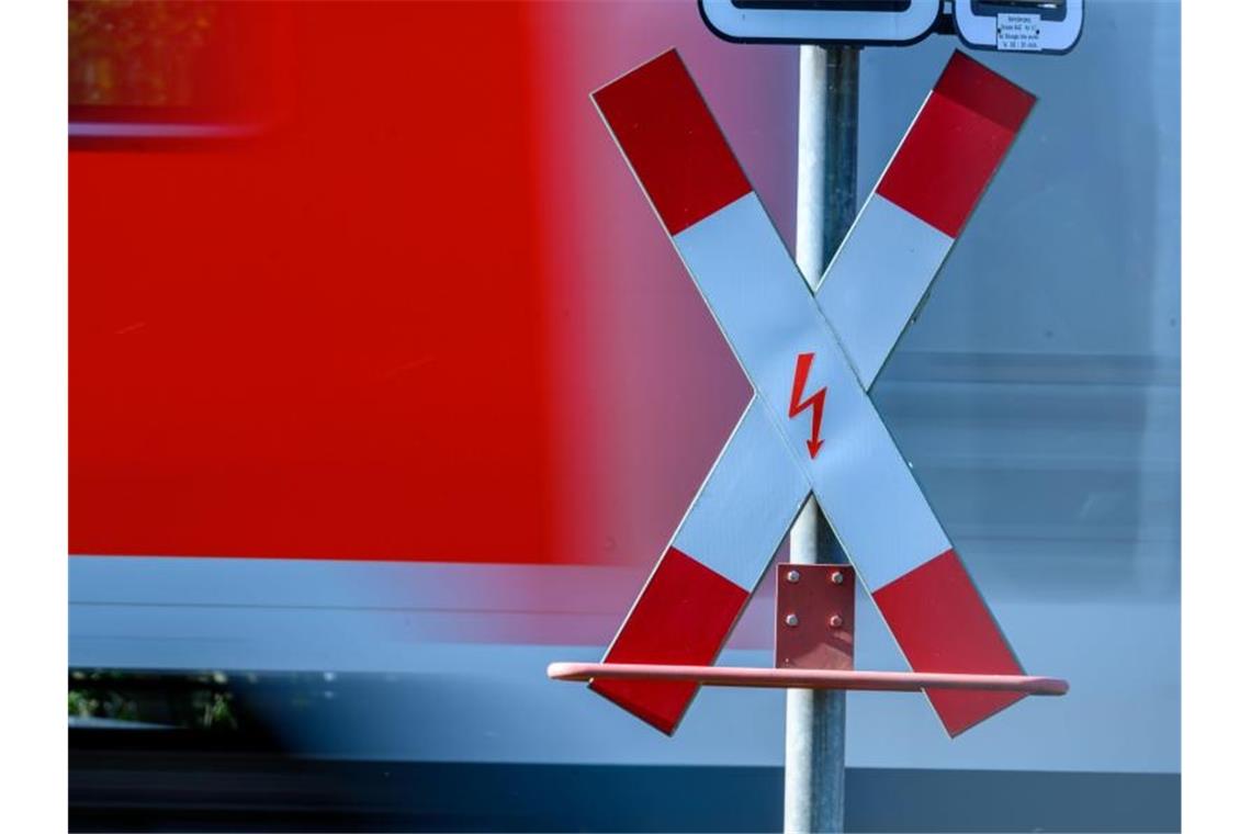 Ein Andreaskreuz steht an einem Bahnübergang. Foto: Jens Büttner/zb/dpa/Archivbild