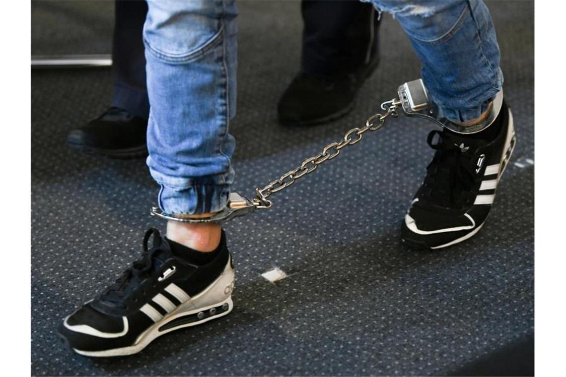 Ein Angeklagter kommt in den Gerichtssaal des Landgerichts mit Fußfesseln. Foto: Patrick Seeger