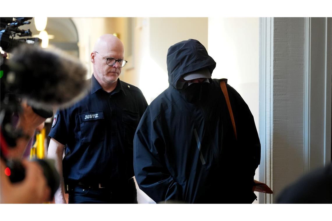 Prozess um Kindesentführung gegen Christina Block gestartet Ein Angeklagter wird von einem Polizisten zum Gerichtssaal begleitet.