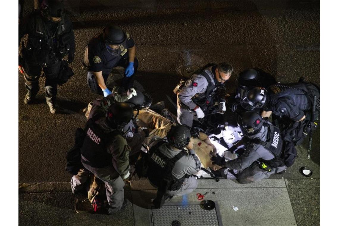 Ein angeschossener Mann wird in Portland von Sanitätern behandelt. Der mutmaßliche Schütze ist offenbar von der Polizei getötet worden. Foto: Paula Bronstein/FR171772 AP/dpa