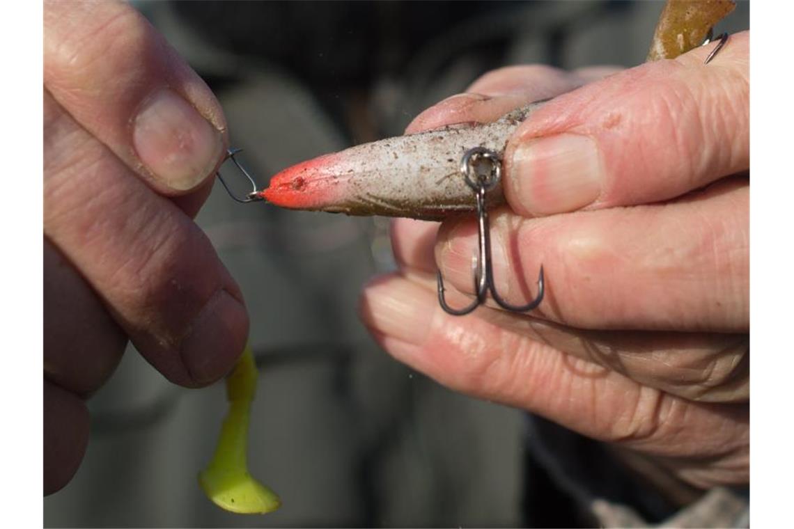 Verband rechnet mit mehr Fisch in Nordsee dank Klimawandel Ein Angler bereitet seine Angel vor und hängt einen Drilling an die Angelschnur. Der Fischereiverband beschäftigt sich derzeit mit dem Kliamwandel. Foto: Klaus-Dietmar Gabbert