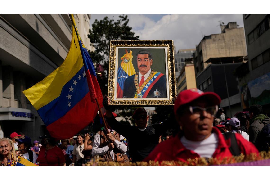 Ein Anhänger der Regierung hält ein Bild von Präsident Nicolas Maduro.