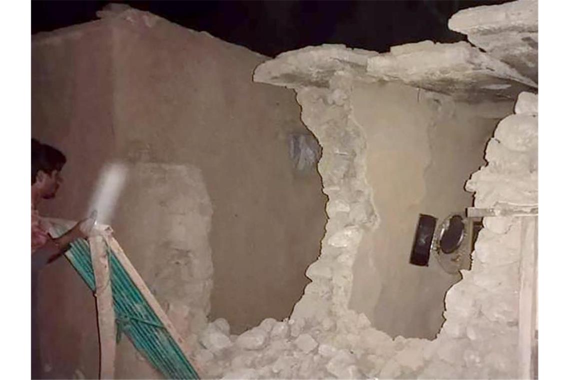 Mindestens 20 Tote nach Erdbeben in Pakistan Ein Anwohner besichtigt sein beschädigtes Haus. Foto: Uncredited/AP/dpa