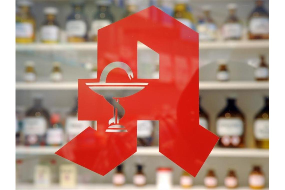 Ein Apothekenlogo befindet sich an einer Glasscheibe. Foto: picture alliance / Uli Deck/dpa/Archivbild