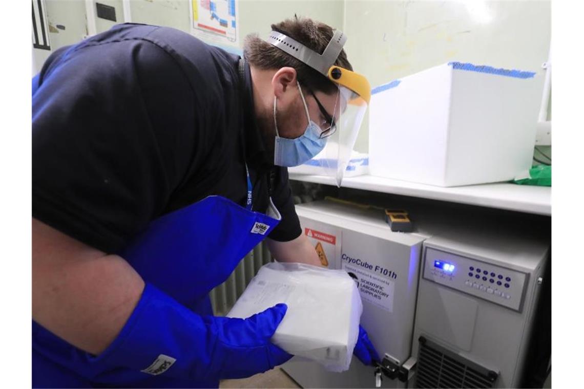 Ein Apothekentechniker des Gesundheitsdienstes von Croydon nimmt im Universitätskrankenhaus Croydon die erste Charge der Covid-19-Impfungen entgegen. Foto: Gareth Fuller/PA Wire/dpa