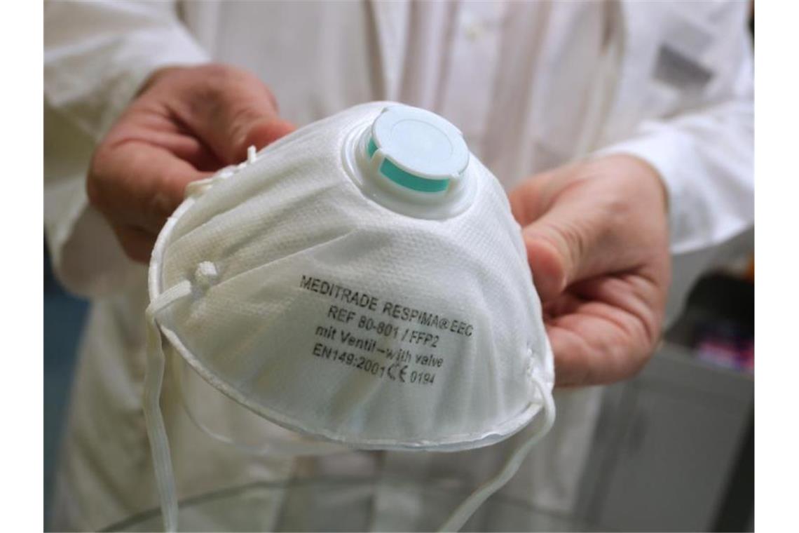 Kliniken rüsten sich für Corona Ein Apotheker hält in einer Apotheke eine Atemschutzmaske. Foto: Karl-Josef Hildenbrand/dpa/Archivbild