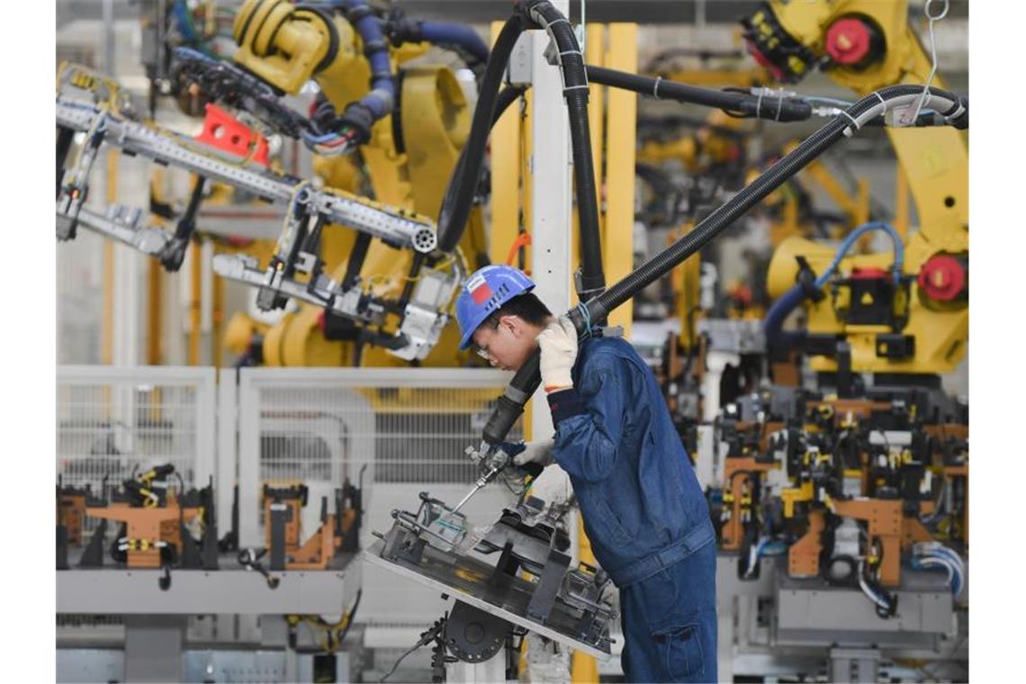 Ein Arbeiter bedient einen Roboter im PKW-Werk der SAIC Motor Corporation Ltd. in der südostchinesischen Provinz Fujian. Foto: Song Weiwei/XinHua/dpa