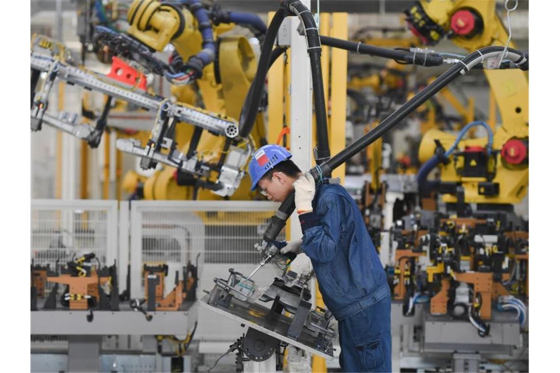 Stimmung in Chinas Wirtschaft auf Zehn-Jahres-Hoch Ein Arbeiter bedient einen Roboter im PKW-Werk der SAIC Motor Corporation Ltd. in der südostchinesischen Provinz Fujian. Foto: Song Weiwei/XinHua/dpa