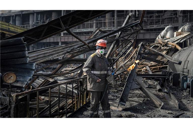 Ein Arbeiter beseitigt die Trümmer des DTEK-Kraftwerks, das von einer russischen Rakete getroffen wurde.