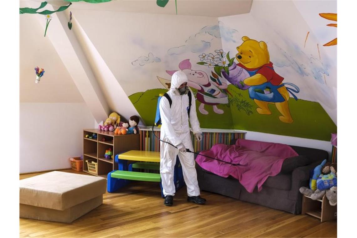 Coronavirus: Kanzlerin Merkel ruft alle zur Solidarität auf Ein Arbeiter desinfiziert die Räumlichkeiten eines Kindergartens im rumänischen Miercurea Ciuc (Szeklerburg). Foto: Nandor Veres/MTI/AP/dpa