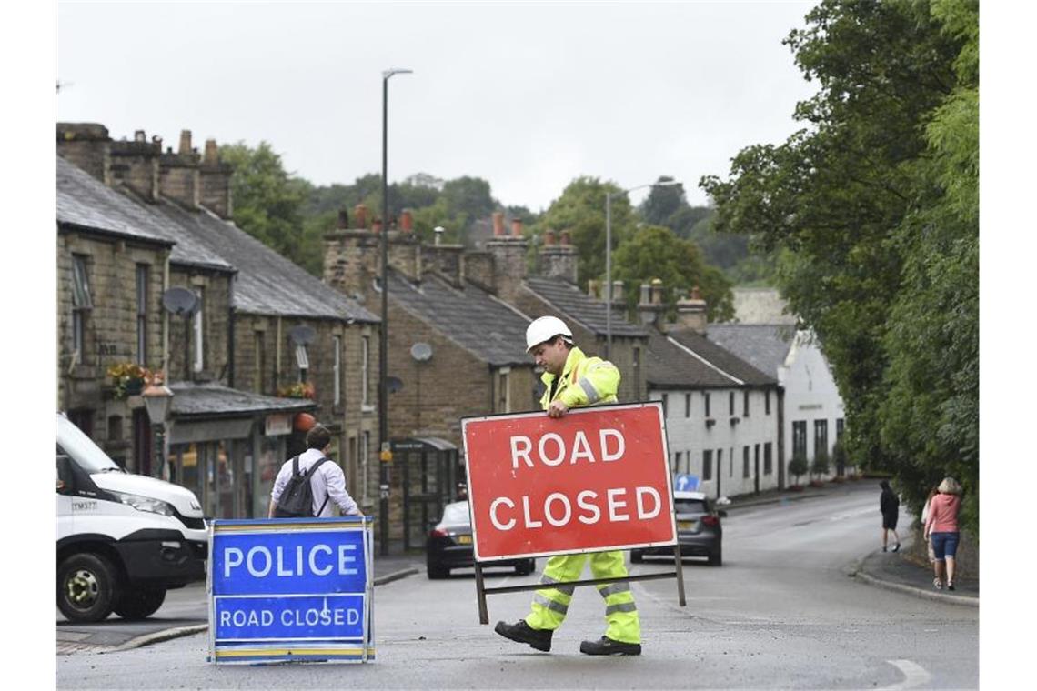 Ein Arbeiter entfernt ein Straßensperrschild. Foto: Joe Giddens/PA Wire