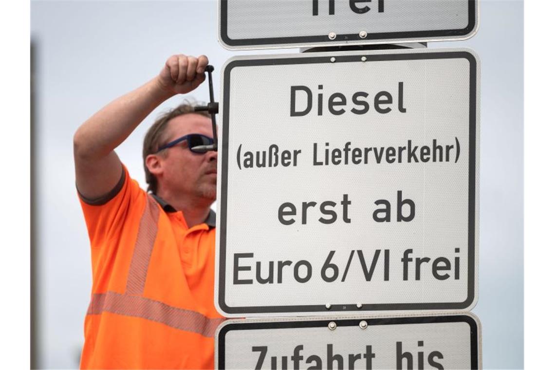 Erste Schilder für erweitertes Dieselfahrverbot in Stuttgart Ein Arbeiter hängt ein Schild auf, das auf ein Fahrverbot für Dieselfahrzeuge der Euronorm 5/V und schlechter hinweist. Foto: Marijan Murat/dpa