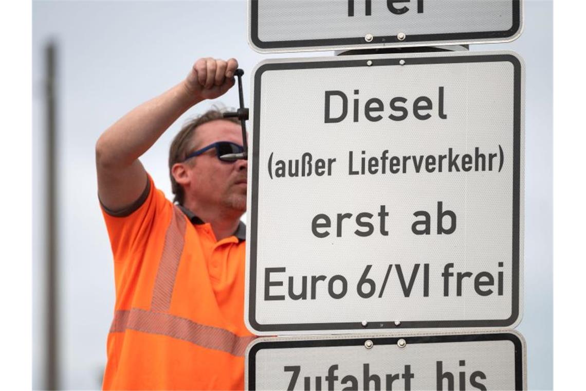 Ein Arbeiter hängt ein Schild auf, das auf ein Fahrverbot für Dieselfahrzeuge der Euronorm 5/V und schlechter hinweist. Foto: Marijan Murat/dpa