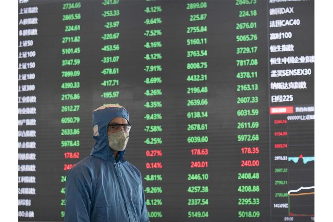 Ein Arbeiter in einem Schutzanzug in der Börse in Shanghai. Foto: -/AP/dpa