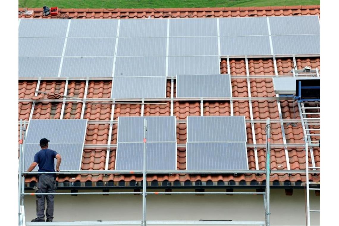 Solarenergieverband: Viele neue Photovoltaikanlagen nötig Ein Arbeiter installiert auf einem Dach eine Solaranlage. Foto: Rolf Haid/dpa/Archivbild