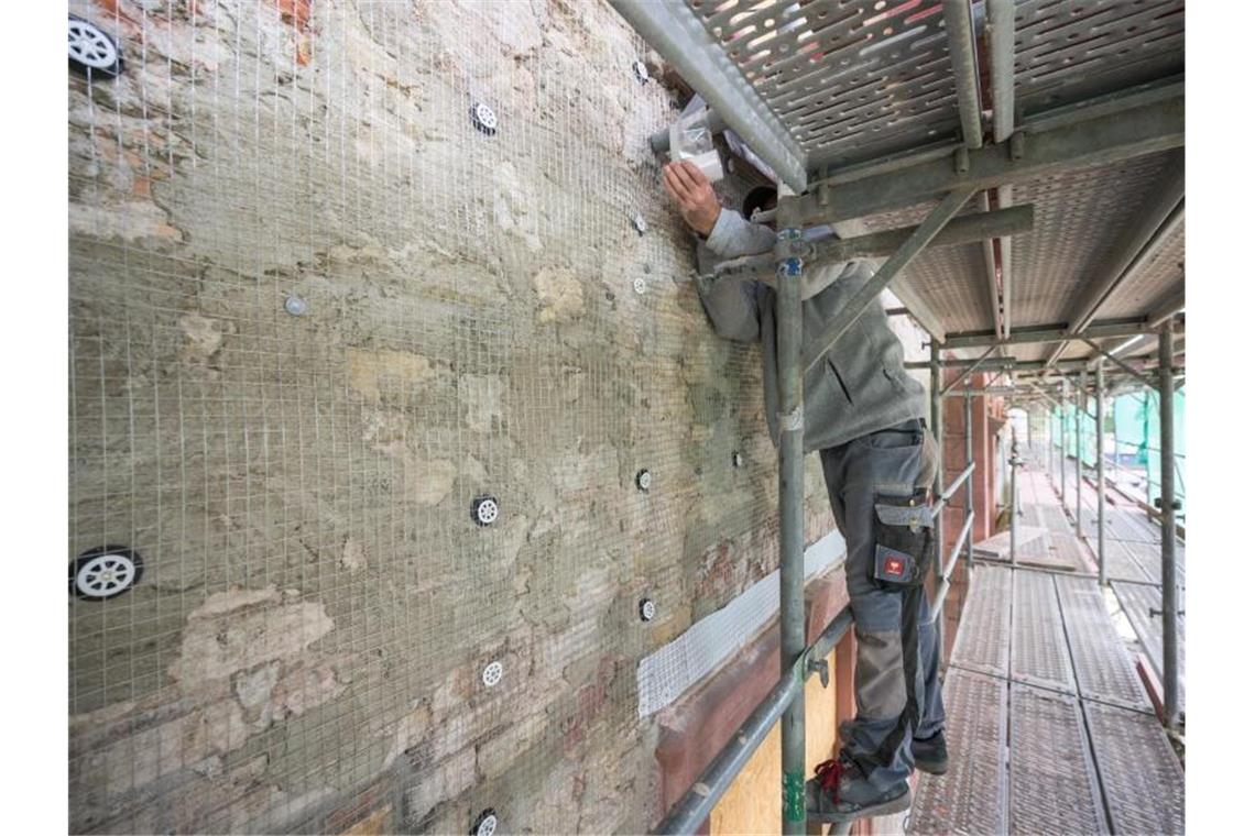 Ein Arbeiter ist mit der Sanierung eines Gebäudes beschäftigt. Viele langlebige Asbestprodukte wie Bodenbeläge oder Dachplatten sind noch immer in Häusern zu finden. Foto: Andreas Arnold/dpa