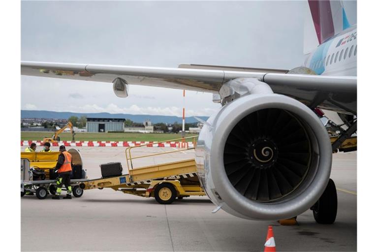 Ein Arbeiter lädt auf dem Vorfeld des Flughafen Stuttgart Gepäck ein. Foto: Marijan Murat/dpa/Symbolbild