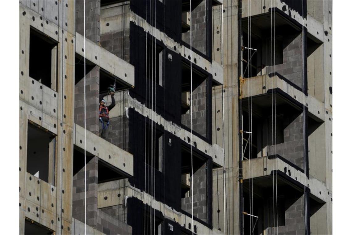 Lockdowns belasten Chinas Unternehmensstimmung Ein Arbeiter mit Gesichtsmaske bohrt in Peking in einem im Bau befindlichen neuen Wohngebäude. Foto: Andy Wong/AP/dpa