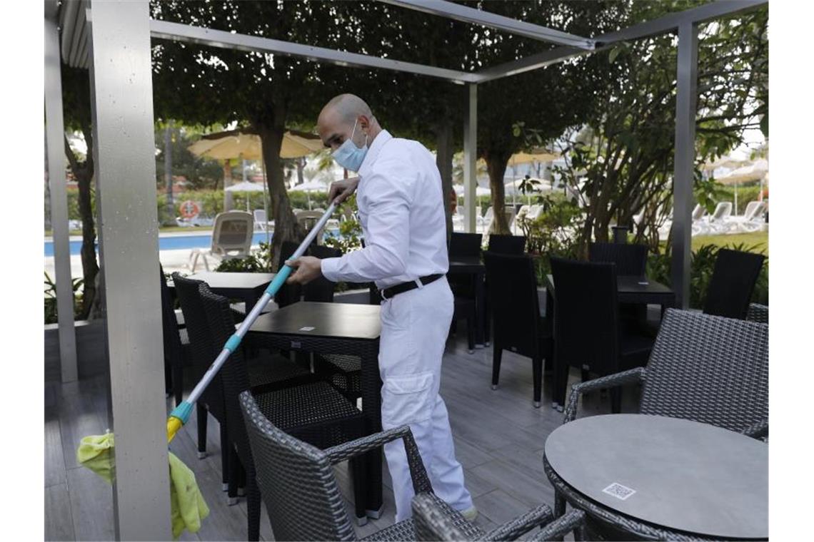 Ein Arbeiter reinigt die Terrasse des Hotels Riu Festival in Palma de Mallorca. Foto: Clara Margais/dpa