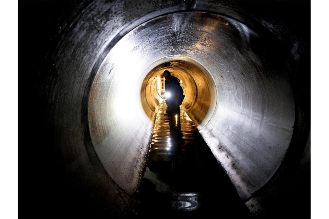 Ein Arbeiter schaut sich 2019 während eines Pressetermines der Berliner Wasserbetriebe in Berlin-Friedenau einen Teil eines neuen, etwa zwei Kilometer langen Wasserkanales an. Foto: Ralf Hirschberger/dpa