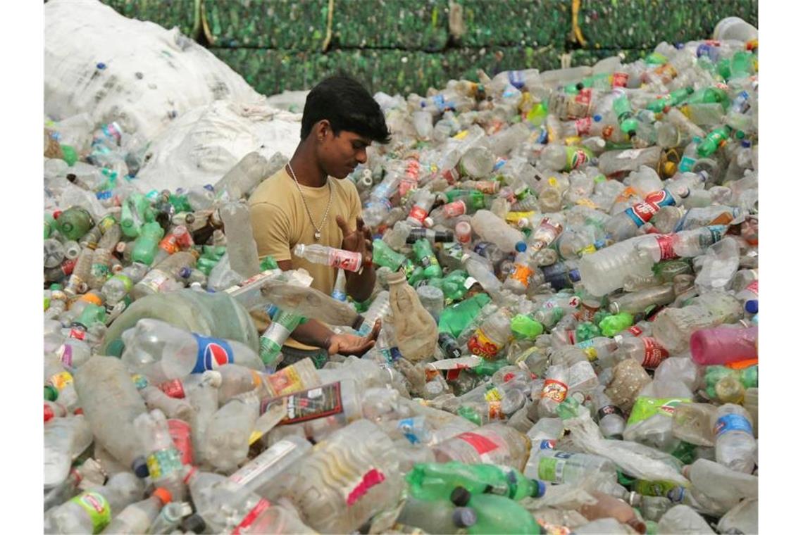 Ein Arbeiter sortiert Plastikflaschen, bevor sie in einer industriellen Anlage am Stadtrand recycelt werden. Indiens Premierminister Modi hat dem Einwegplastik den Kampf angesagt. Foto: Channi Anand/AP/dpa