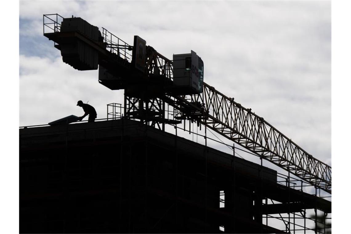 Bauarbeiter erhalten Wege-Entschädigung und „Corona-Prämie“ Ein Arbeiter steht auf dem Dach des Rohbaus eines Mehrfamilienhauses in einem neuen Wohnquartier. Foto: Julian Stratenschulte/dpa