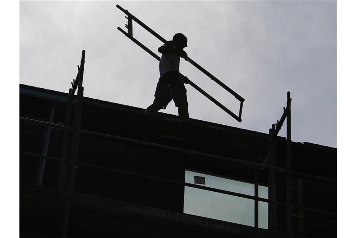 Ausbildungszahlen in der Bauwirtschaft steigen Ein Arbeiter trägt auf einer Baustelle ein Teil eines Baugerüsts. Foto: Britta Pedersen/dpa-Zentralbild/dpa/Symbolbild