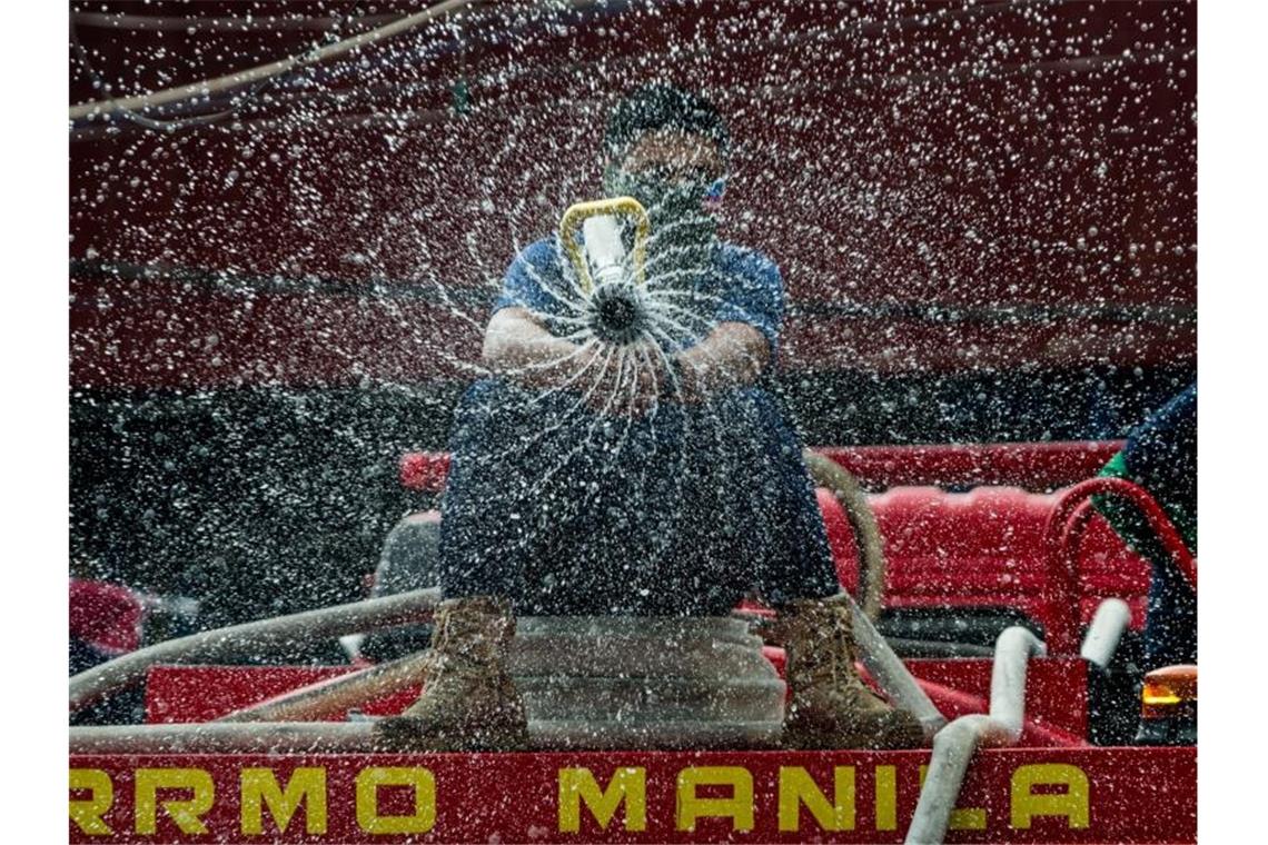 Coronavirus: Kanzlerin Merkel ruft alle zur Solidarität auf Ein Arbeiter versprüht Desinfektionsmittel in der Nähe eines Marktes in Manila (Philippinen). Foto: Lisa Marie David/ZUMA Wire/dpa