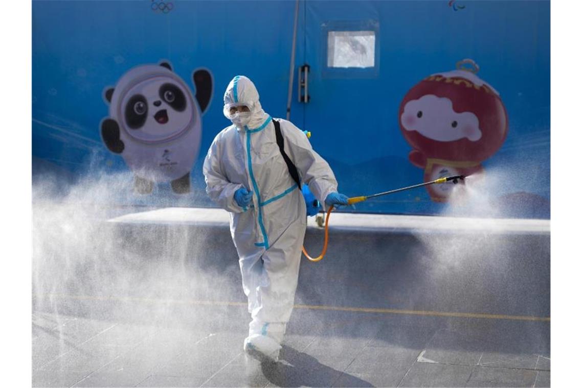 Das war die Olympia-Nacht Ein Arbeiter versprüht Desinfektionsmittel vor einem Hotel in Peking. Foto: Natacha Pisarenko/AP/dpa