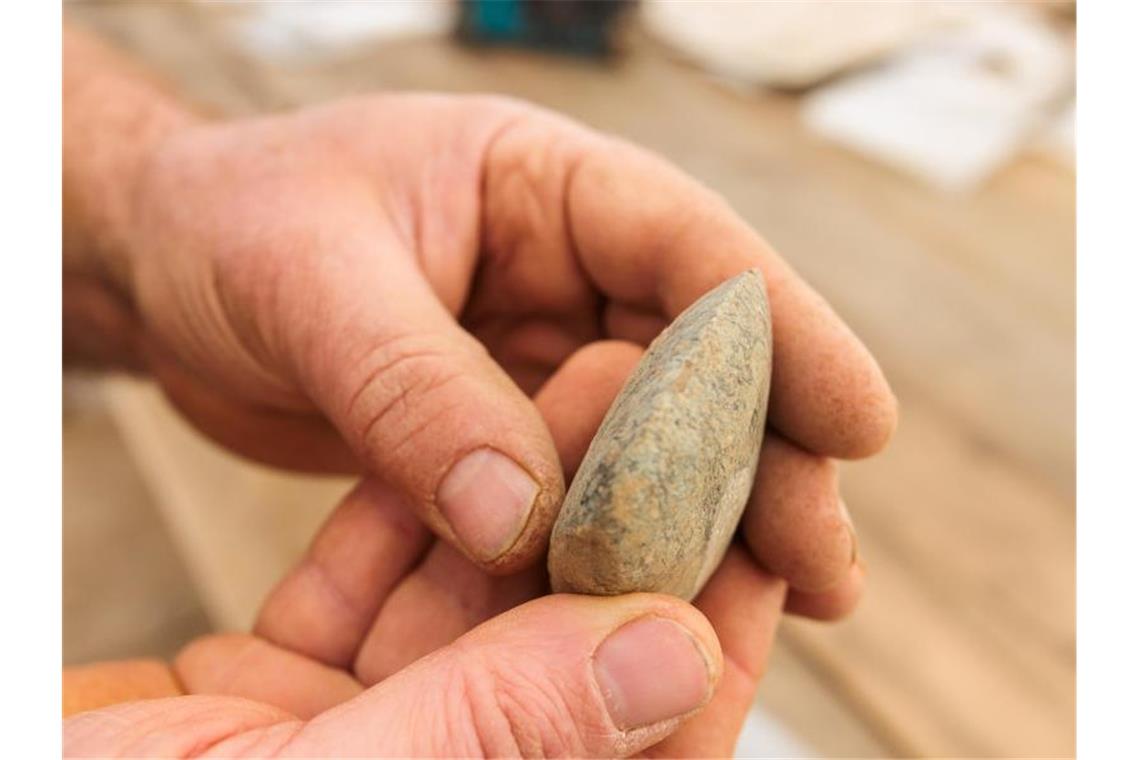 Jahrtausendealte römische Siedlungsfunde vorgestellt Ein Archäologe hält eine Beil-Klinge aus dem Neolithikum (Jungsteinzeit) in der Hand. Foto: Philipp von Ditfurth/dpa/Archivbild